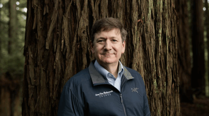 Steve Mietz, Save the Redwoods League CEO, wears a blue jacket and stands in front of redwood tree. 